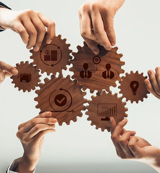 Multiple hands holding interconnected wooden gears with business and innovation icons.